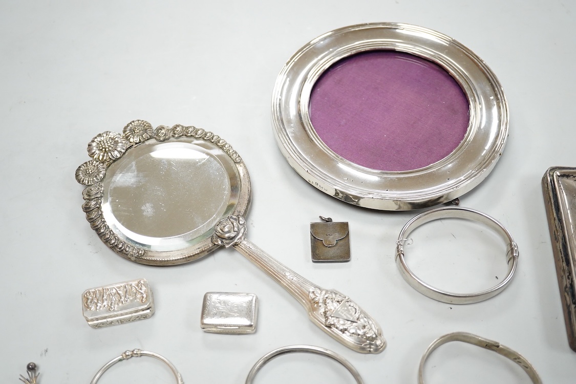 A small group of silver items including a William IV vinaigrette, William Simpson, Birmingham, 1835, 30mm, a later stamp case, two mounted photograph frames, two hinged bangles, together with a group of sterling or white